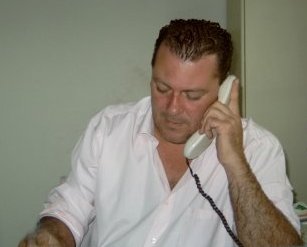 Mann spricht am Telefon, sucht Handwerker, Kundenservice.